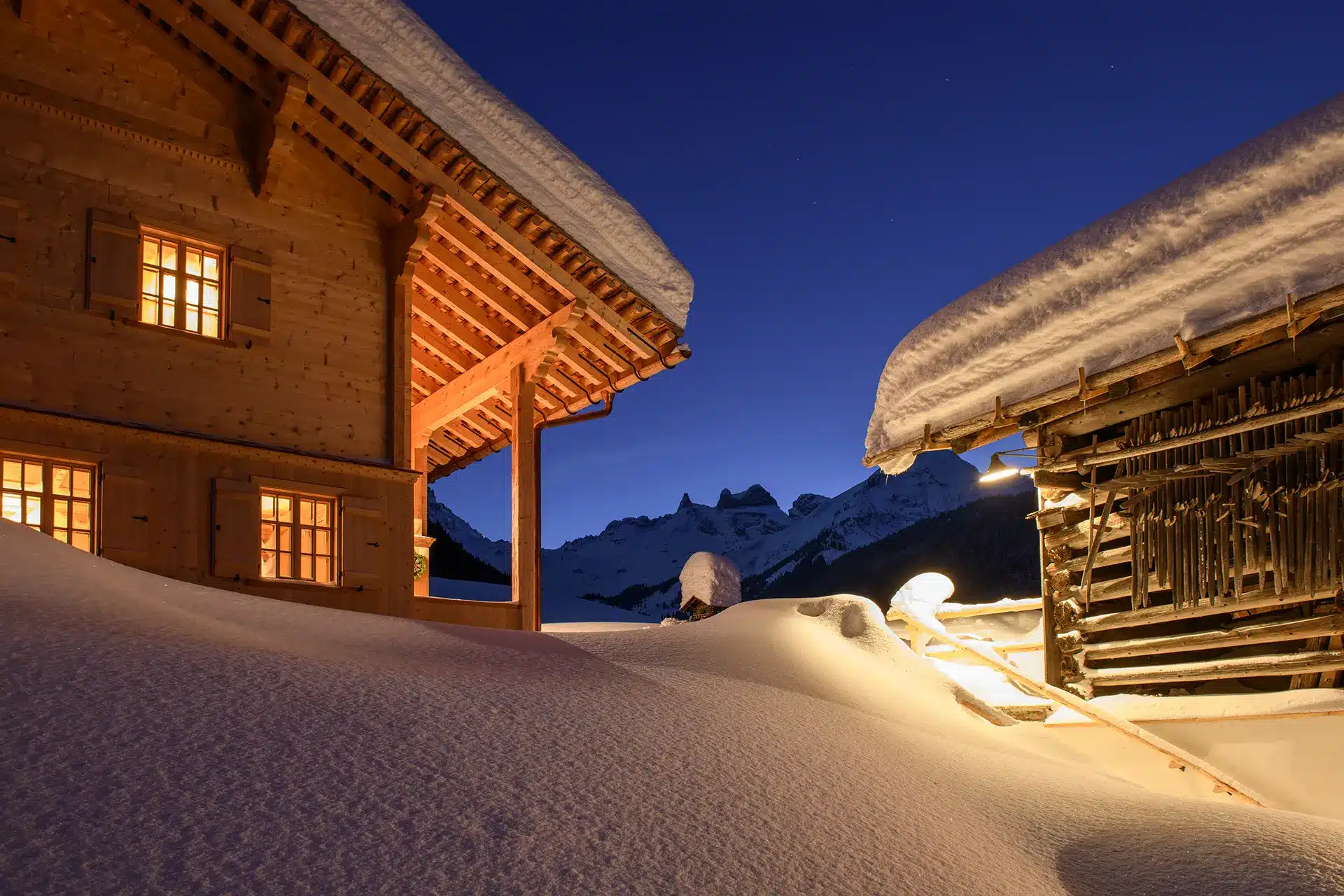 Schneebedeckte Chalets in der Nacht mit Blick auf die 3 Türme